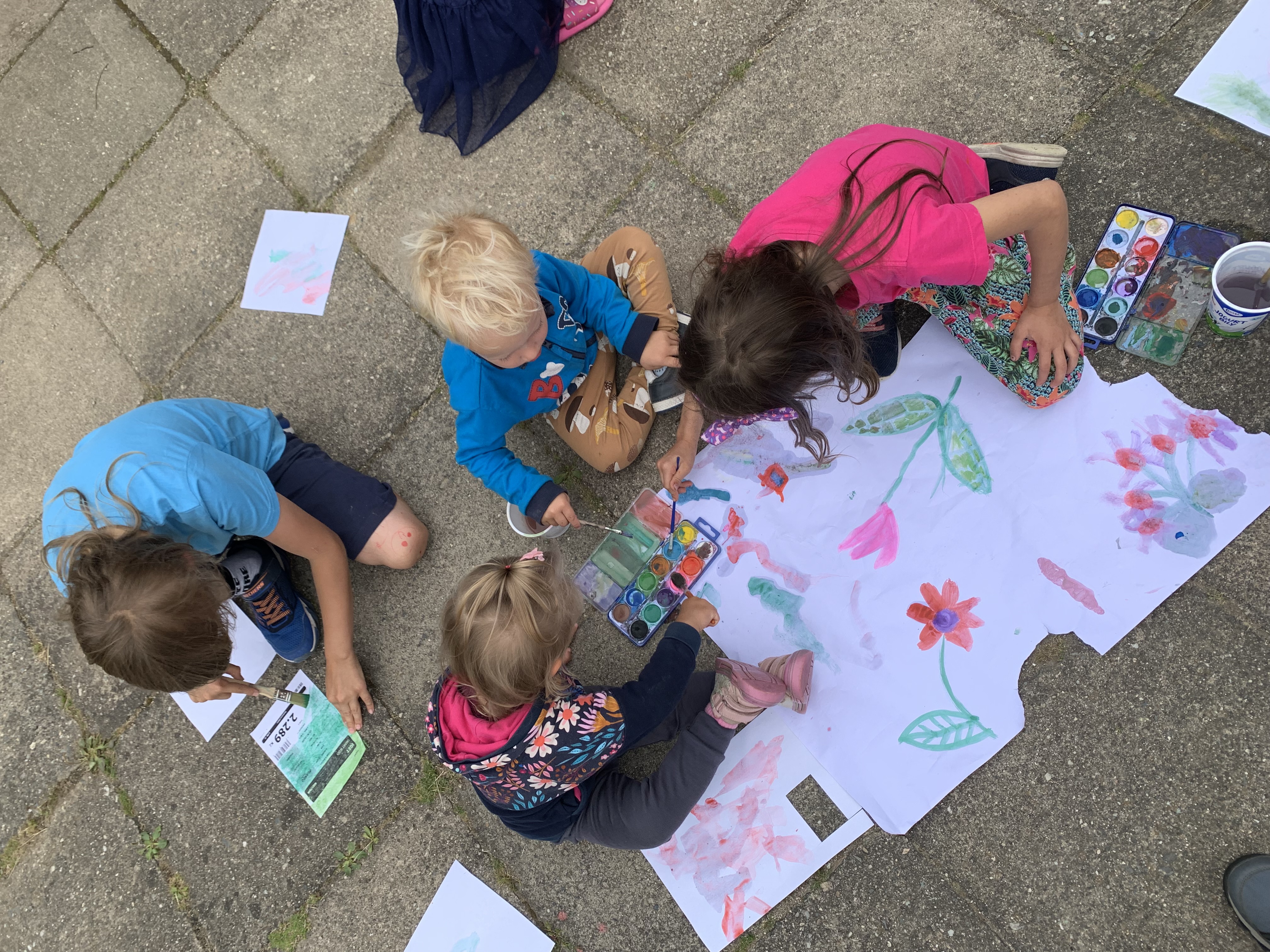 Děti si malují na chodníku